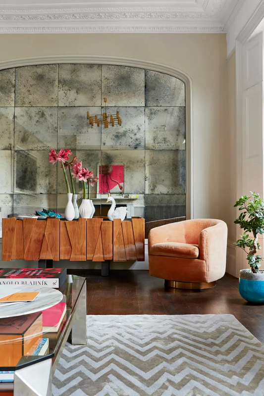 large smoked wall mirror in a modern living room to create depth and make living room feel larger