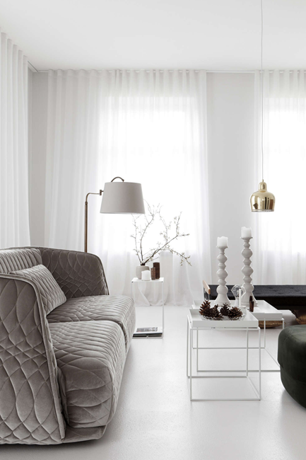 grey modern loveseat in a all white small living room